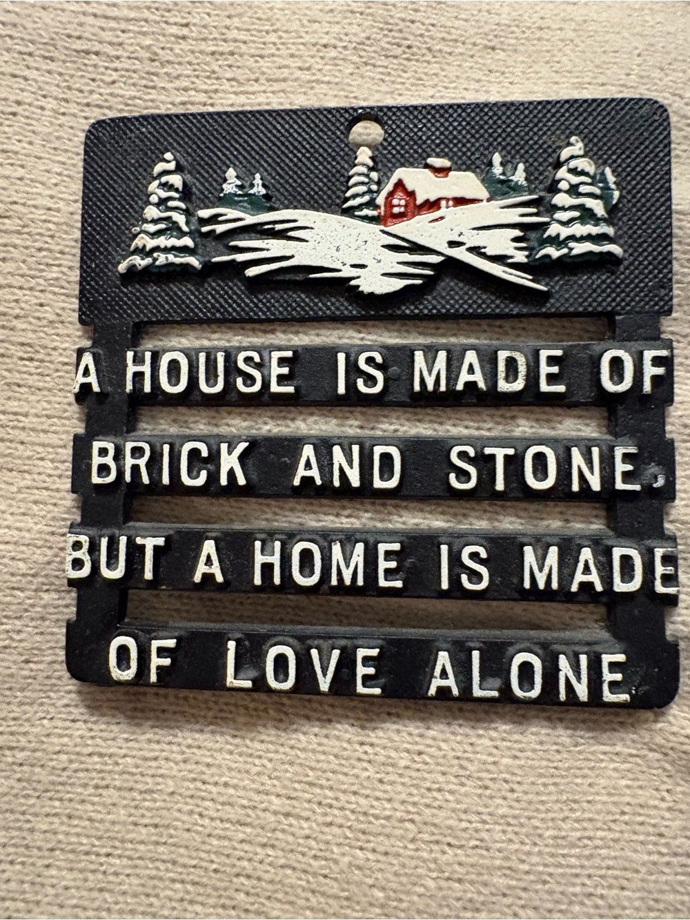Vintage black metal trivet featuring a house scene and a sentimental quote.